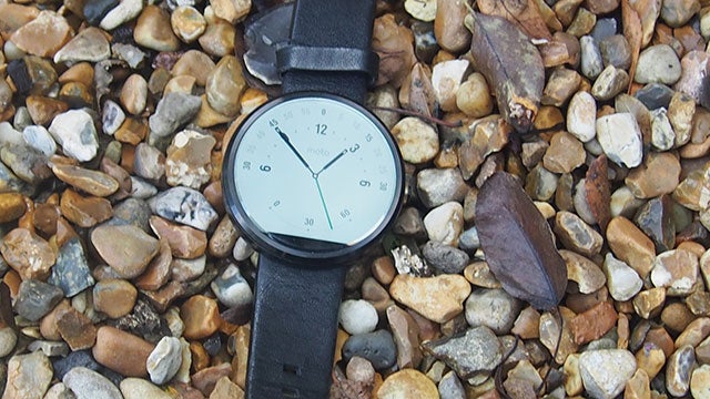 Moto 360 smartwatch on a bed of pebbles.