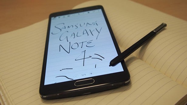 Samsung Galaxy Note 4 with stylus on notebook displaying handwriting feature.