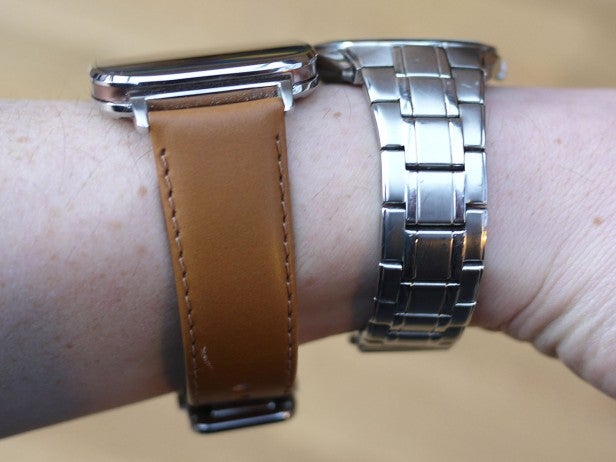 Two smartwatches with different bands on a wrist
