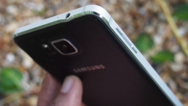 Samsung Galaxy Alpha smartphone on pebble surfaceClose-up of Samsung Galaxy Alpha smartphone held in hand.