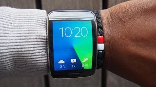 Person wearing Samsung Gear S smartwatch displaying time and weather.