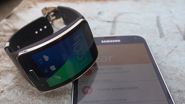 Smartwatch beside smartphone displaying pairing screen.