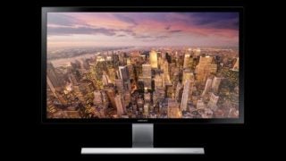 Samsung U28D590D monitor displaying a cityscape at sunset.