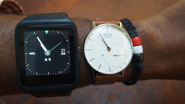 Sony SmartWatch 3 beside a traditional wristwatch on arm.