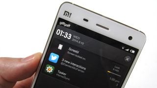 Hand holding Xiaomi Mi4 displaying notifications on screen