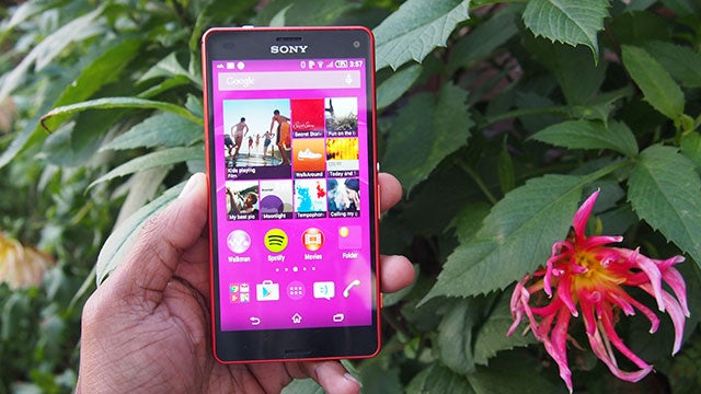 Hand holding a Sony Xperia Z3 Compact outdoors with apps on screen