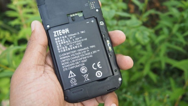 Hand holding a phone showing its removable battery.