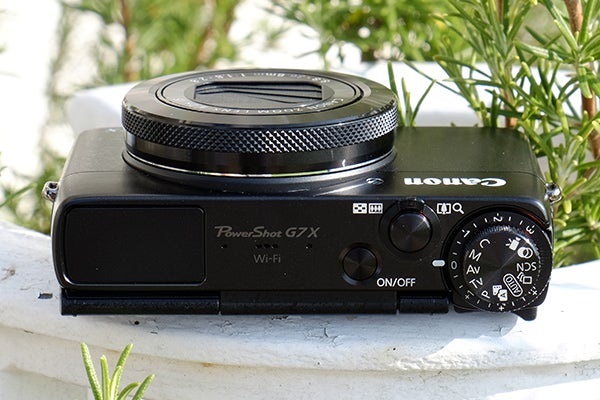 Canon PowerShot G7 X camera on outdoor ledge.