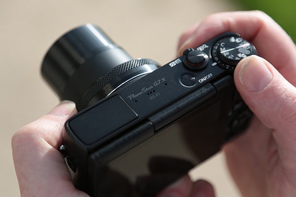 Close-up of a Canon PowerShot G7 X camera held in hand.
