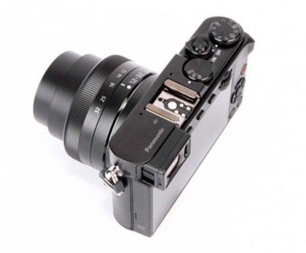 Compact digital camera with lens and manual controls.