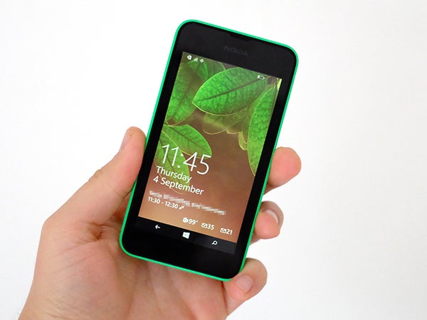 Hand holding a green Nokia Lumia 530 smartphone.