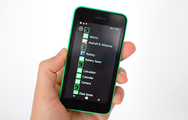Hand holding Nokia Lumia 530 displaying apps menu.
