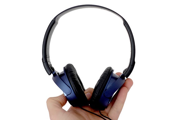 Hand holding Sony MDR-ZX310 foldable headphones.