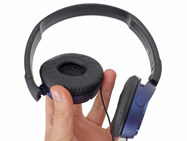Hand holding Sony MDR-ZX310 foldable headphones.