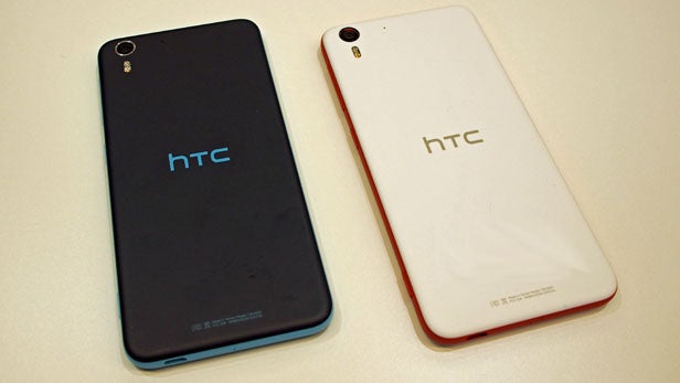 Two HTC Desire EYE smartphones in blue and red colors.HTC Desire EYE smartphone on wooden surface.