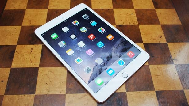 iPad mini 3 on a wooden chess board surface.
