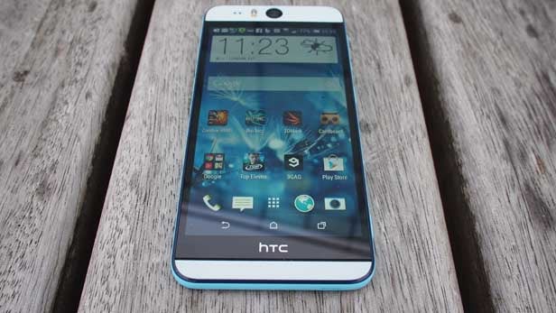 HTC Desire EYE smartphone on wooden surface.