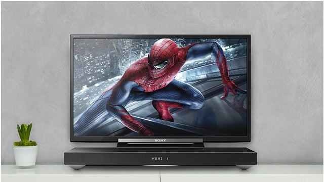 Sony HT-XT1 sound base with TV displaying Spider-Man.