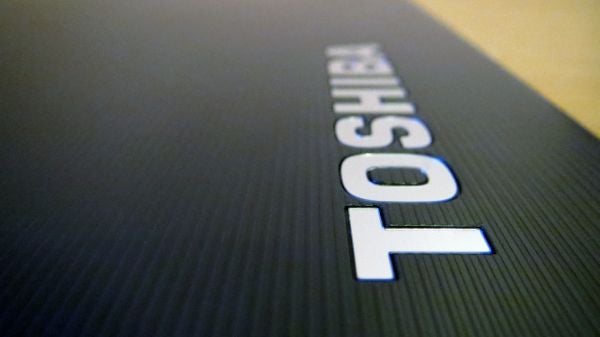 Close-up of Toshiba logo on laptop lid texture.