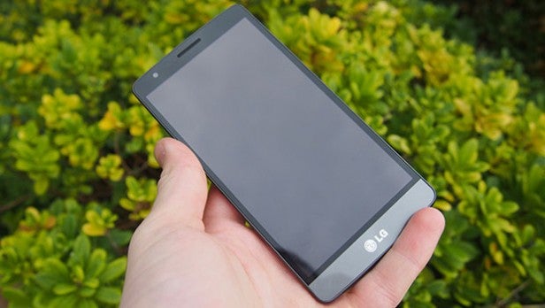 LG G3 SHand holding LG smartphone with blank screen outdoors.