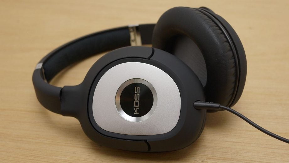 Koss SP540 headphones with cord on wooden surface.