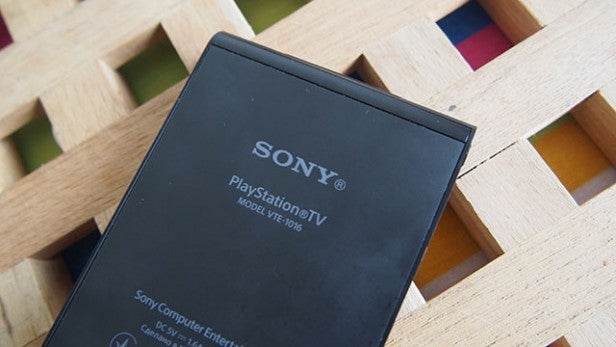 Sony PlayStation TV device on a wooden surface.