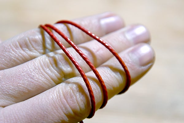 Hand with a red string wrapped around fingers
