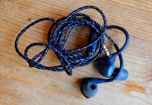 Tangled Audiofly AF140 in-ear monitors on wooden surface.