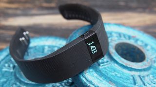 Fitbit Charge on blue weight plate showing step count.