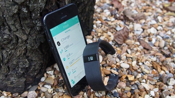 Fitbit Charge on phone screen next to the wristband.