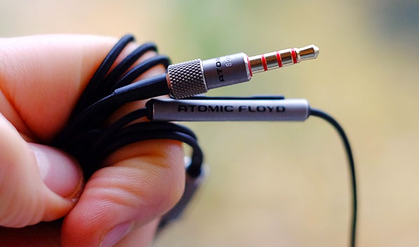 Atomic Floyd SuperDarts Titanium earphones held in hand