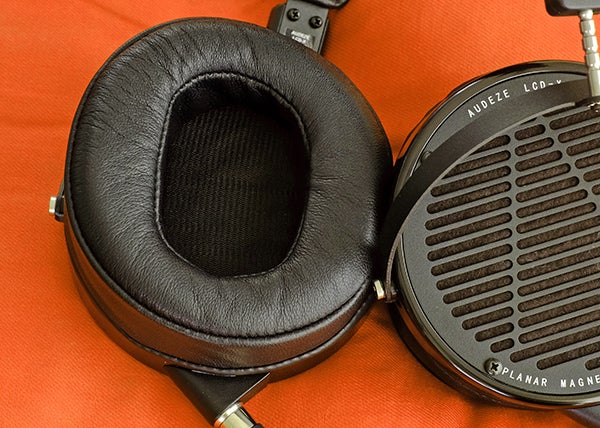 Audeze LCD-X over-ear headphones on an orange background.