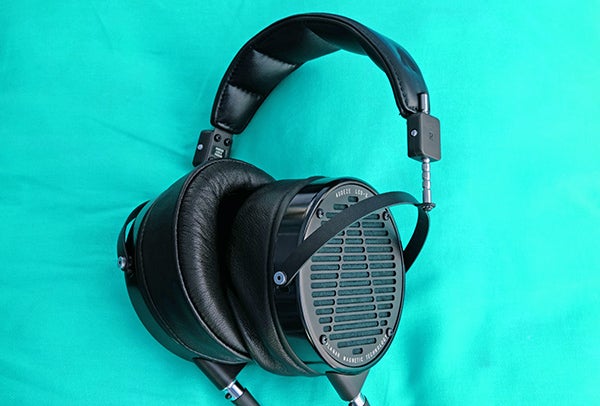 Audeze LCD-X over-ear planar magnetic headphones on teal background.