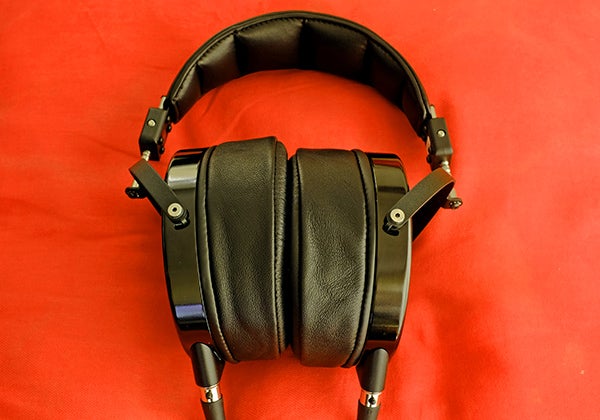 Audeze LCD-X over-ear headphones on red background.