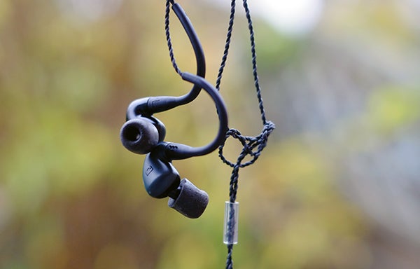 Audiofly AF140 in-ear monitors hanging against blurred background.