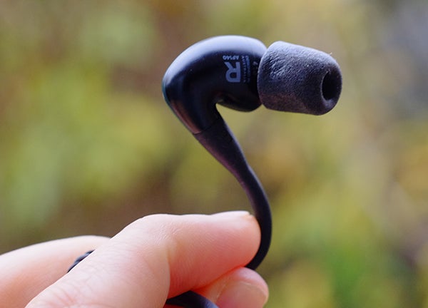 Close-up of a hand holding an Audiofly AF140 in-ear monitor.