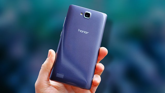 Hand holding Honor 3C smartphone with logo visible.