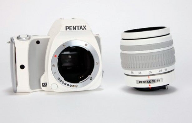 White Pentax DSLR camera body and zoom lens.