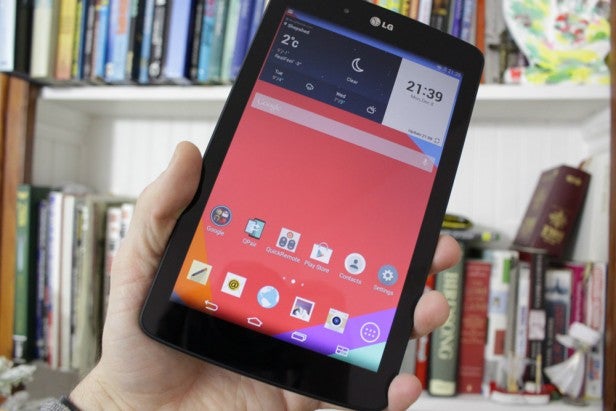 LG G Pad 7.0Hand holding a tablet displaying apps on screen with bookshelf background