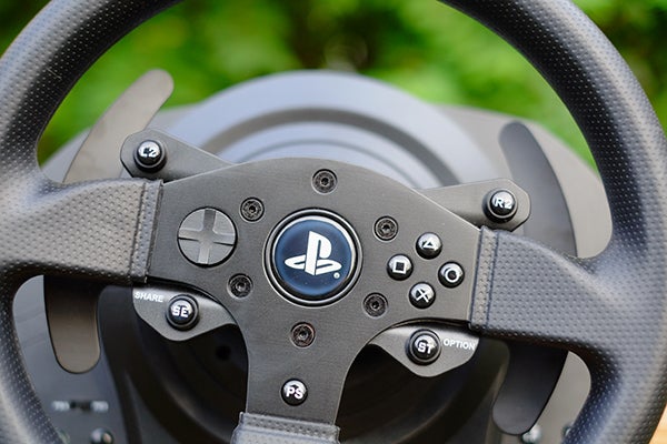 Close-up of Thrustmaster T300 RS racing wheel with PlayStation buttons.