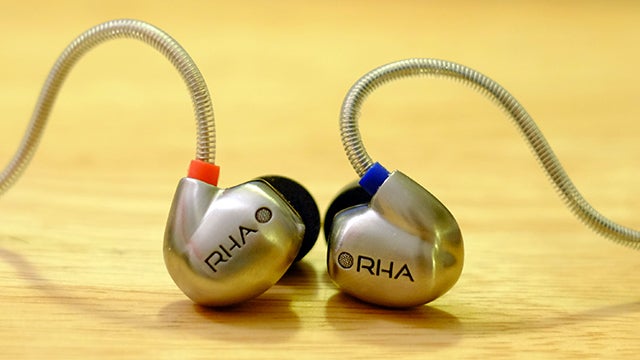 RHA T10i in-ear headphones on wooden surface.