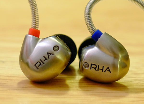 RHA T10i earphones on wooden surface.