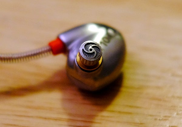 Close-up of RHA T10i earpiece on wooden surface.