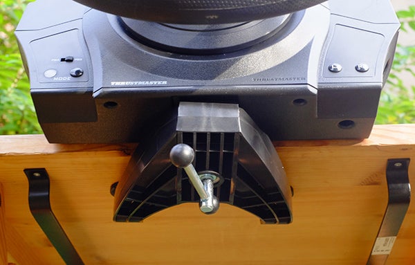 Thrustmaster T300 RS racing wheel mounted on a wooden stand.