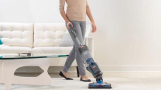 Person using Vax Air Cordless U86-AL-B vacuum cleaner in living room.