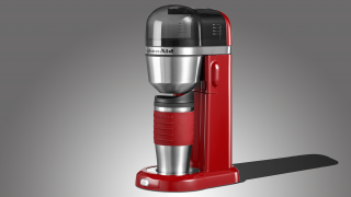 KitchenAid Personal Coffee Maker in red on a gray background.