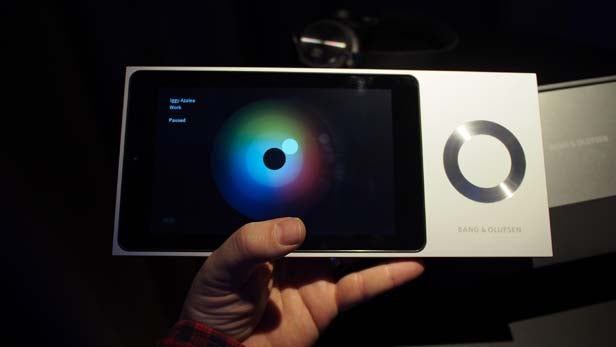 Hand holding BeoSound Moment interface with color wheel.