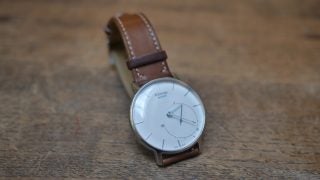 Withings Activité watch with brown leather strap on wooden surface
