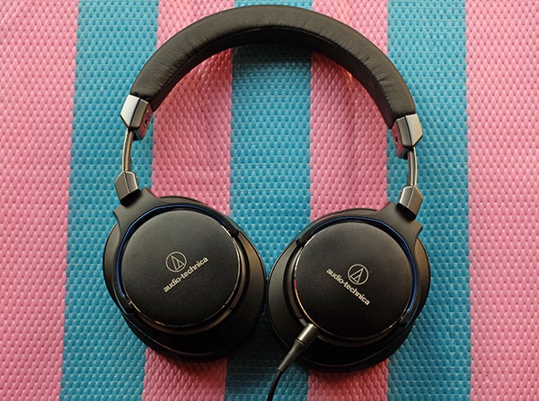 Audio-Technica ATH-MSR7 headphones on pink and blue mat.
