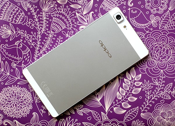 Oppo R5 smartphone on purple floral pattern background.